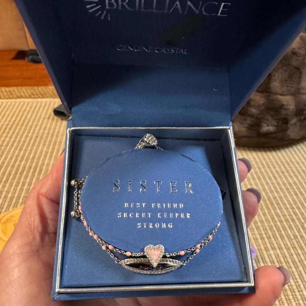Brilliance bracelet features a heart charm and a "Sister" charm